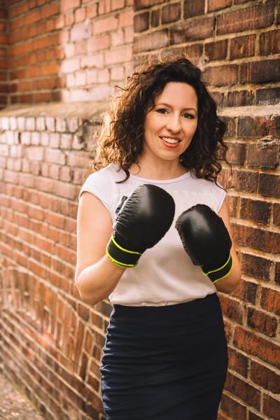 claudia behlendorf mit boxhandschuhen vor natursteinwand